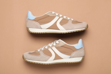 Photo of Pair of stylish sneakers on beige background, flat lay. Casual shoes