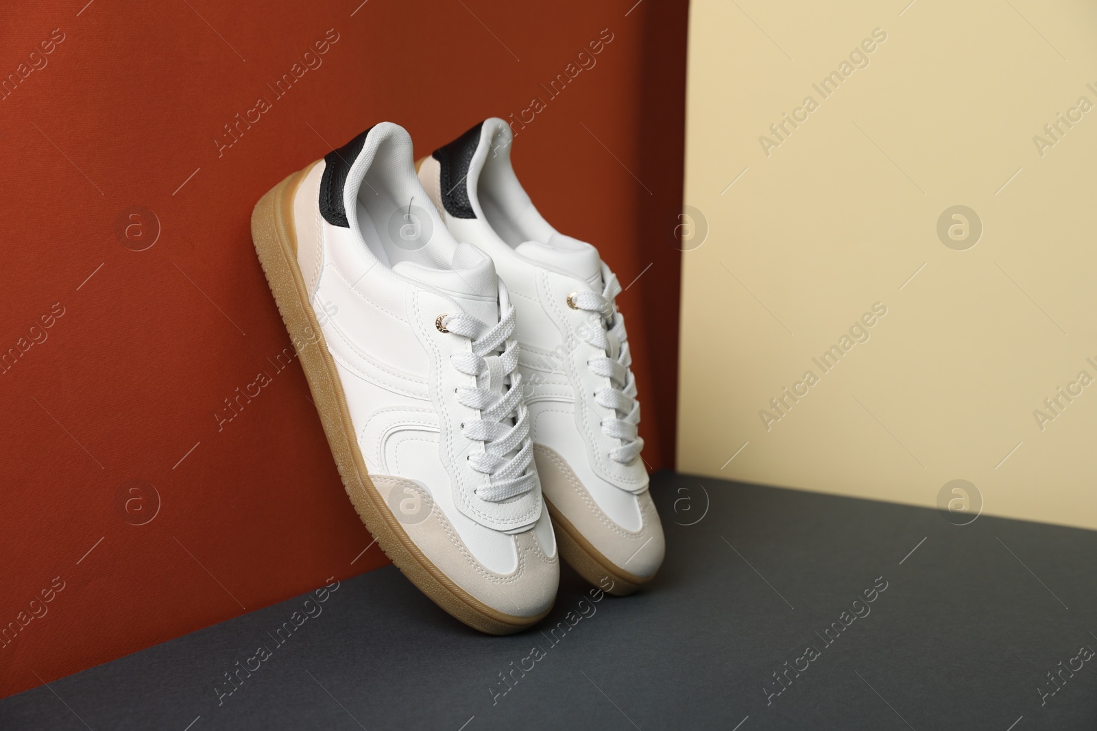 Photo of Pair of stylish sneakers on color background, space for text. Casual shoes