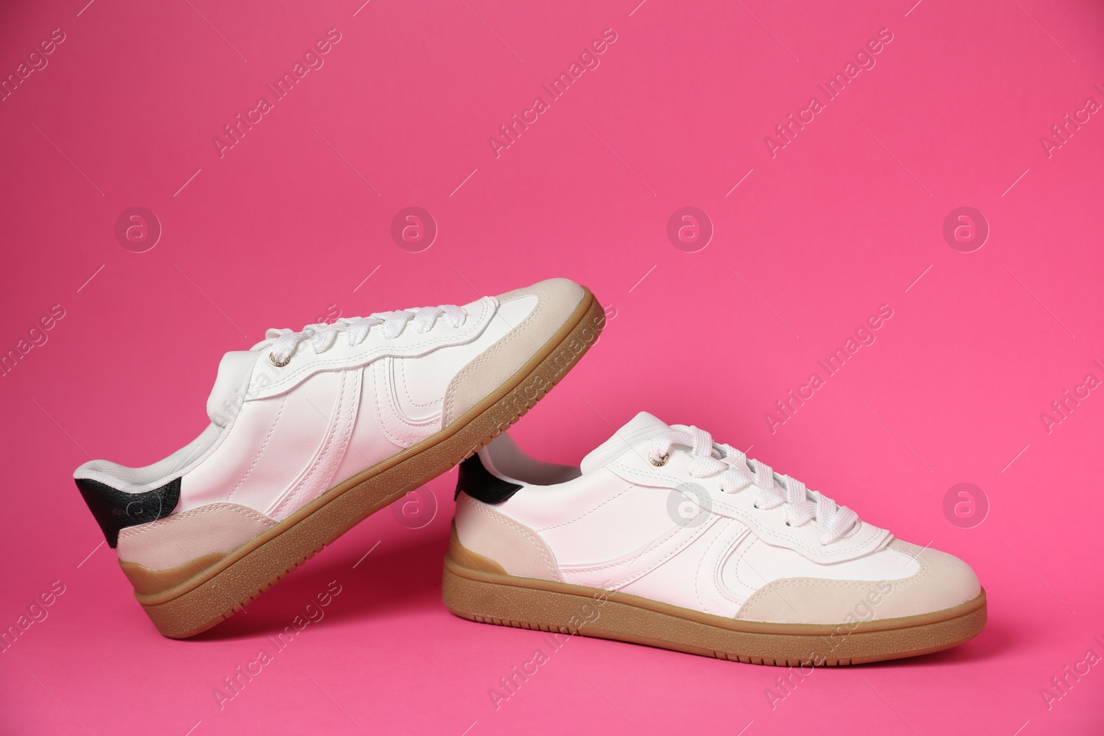 Photo of Pair of stylish sneakers on pink background. Casual shoes