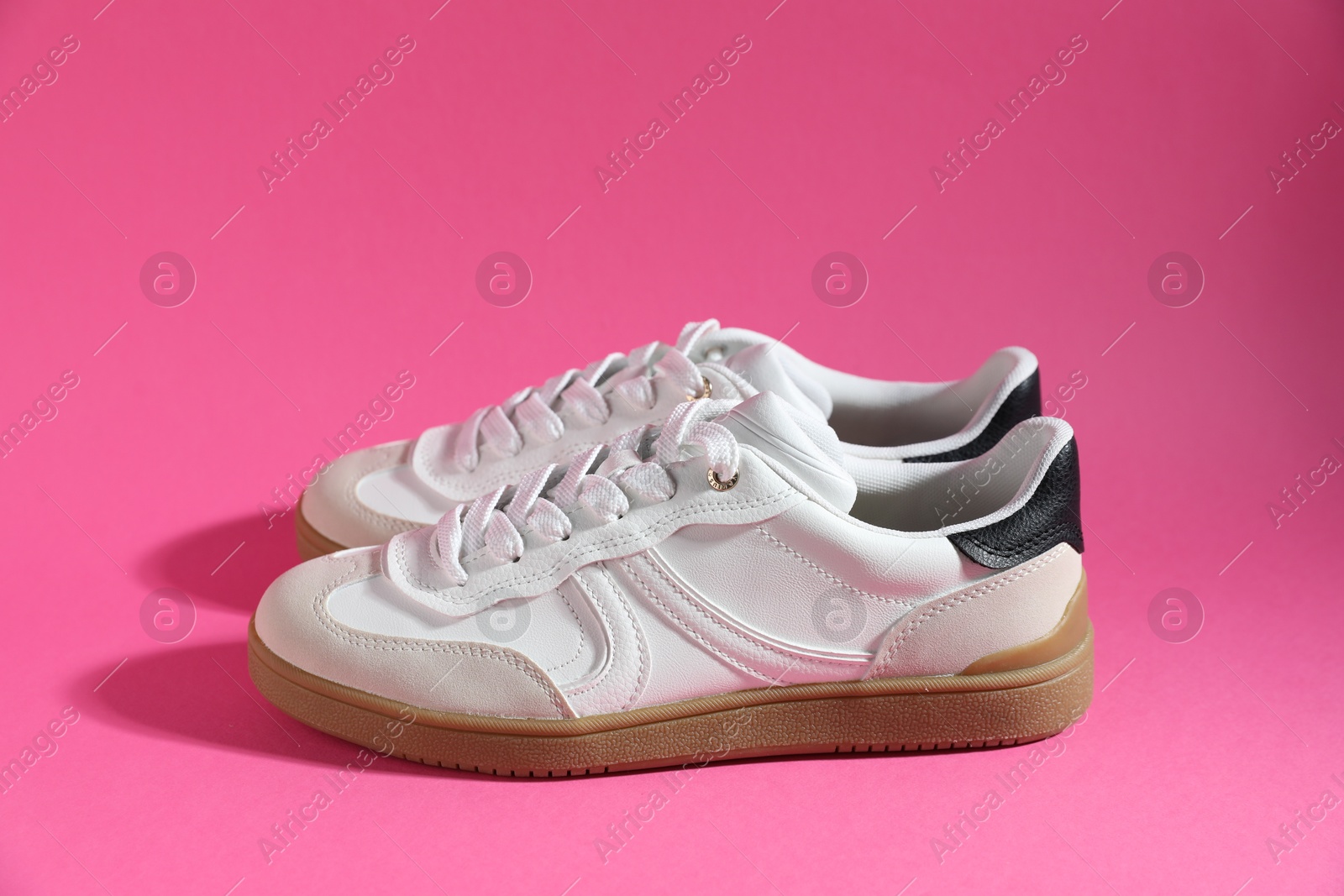 Photo of Pair of stylish sneakers on pink background. Casual shoes