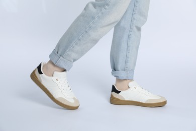 Photo of Woman wearing stylish sneakers on white background, closeup