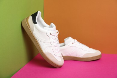 Photo of Pair of stylish sneakers on color background