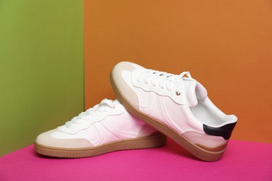 Photo of Pair of stylish sneakers on color background