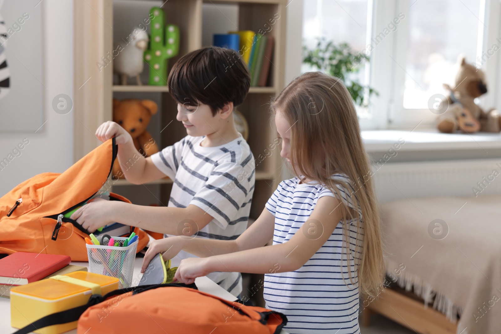 Photo of Kids getting ready for school at table indoors