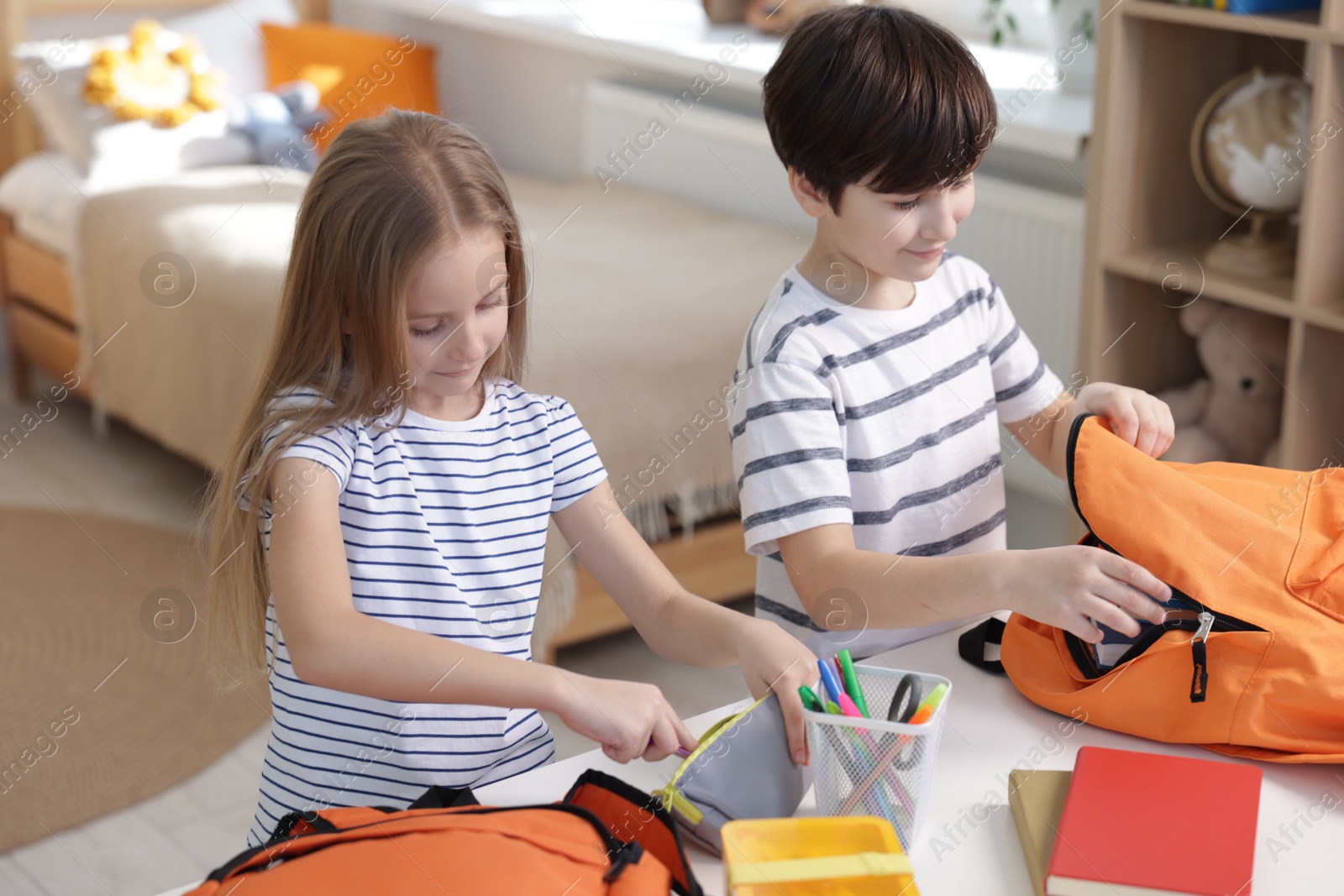 Photo of Kids getting ready for school at table indoors