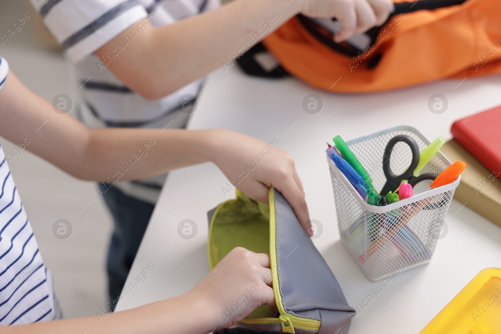 Photo of Kids getting ready for school at table indoors, closeup