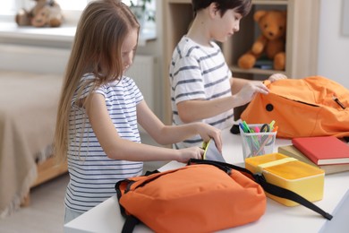 Kids getting ready for school at table indoors