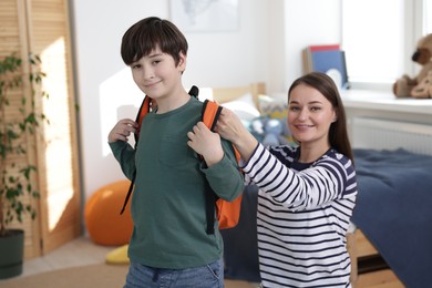 Mother helping her son get ready for school at home