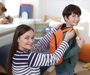 Mother helping her son get ready for school at home