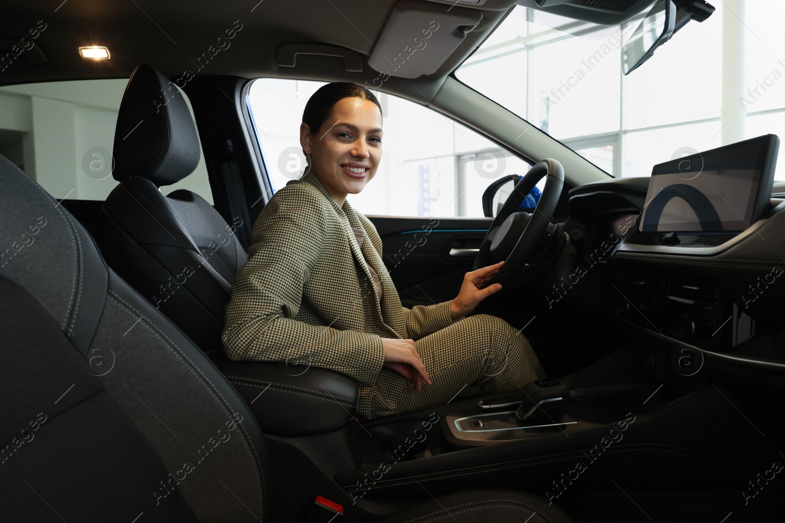 Photo of Happy woman inside new car in salon