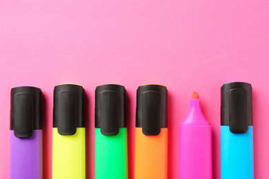 Photo of Bright highlighters on pink background, flat lay. Space for text