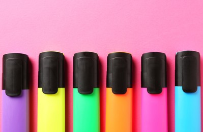 Photo of Bright highlighters on pink background, flat lay