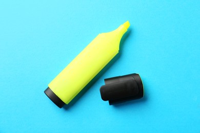 Photo of Bright highlighter and cap on light blue background, flat lay