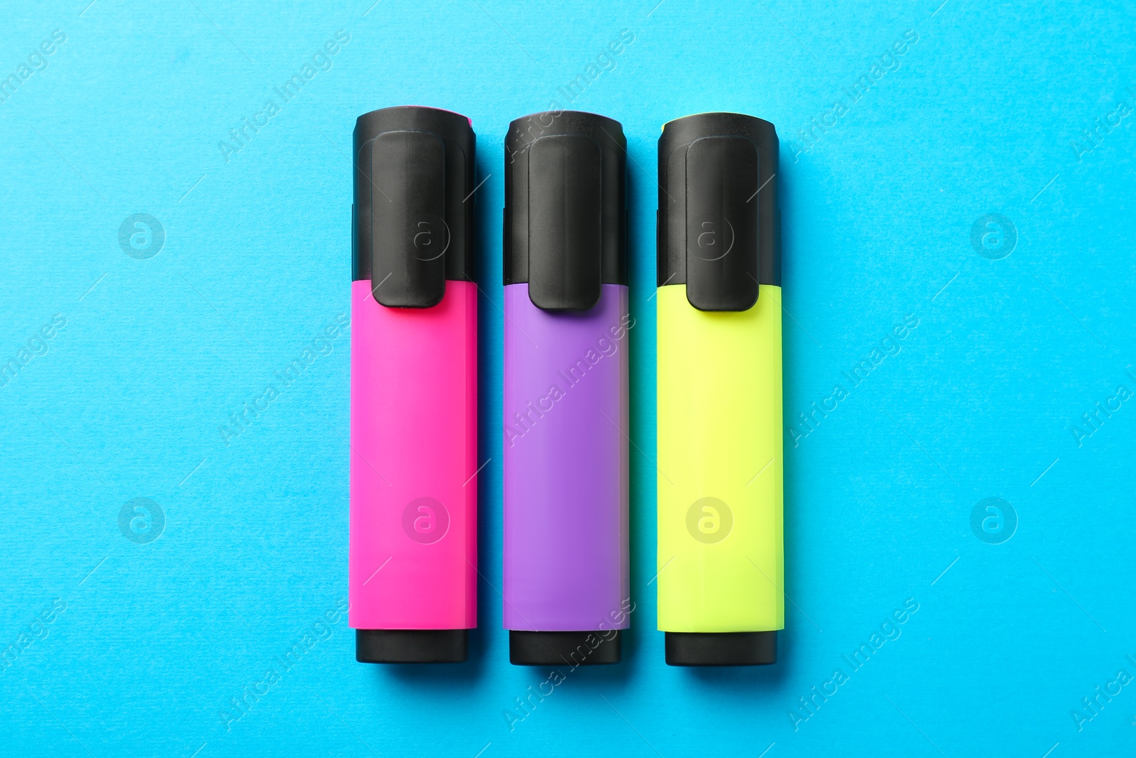 Photo of Bright highlighters on light blue background, flat lay