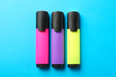 Photo of Bright highlighters on light blue background, flat lay