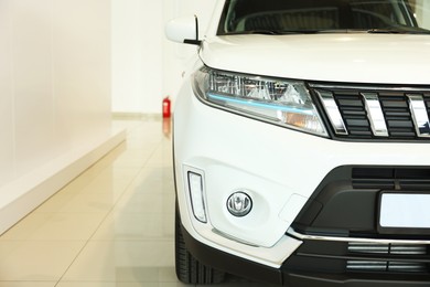 Photo of New modern white car in salon, space for text