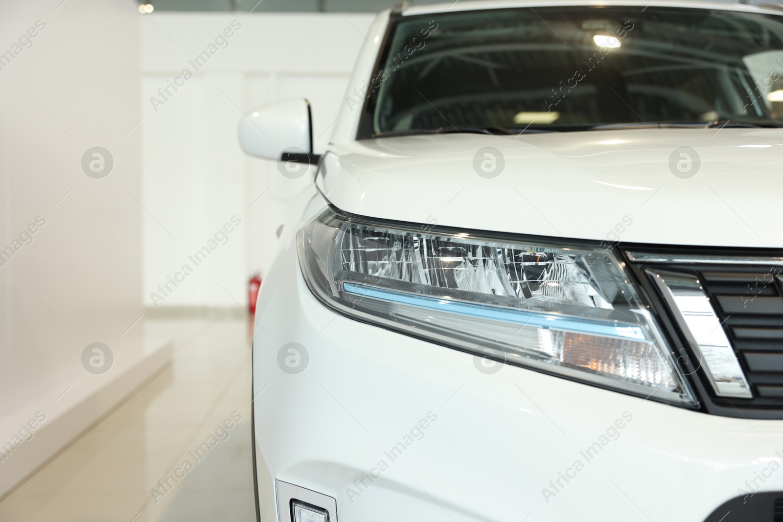 Photo of New modern white car in salon, closeup. Space for text