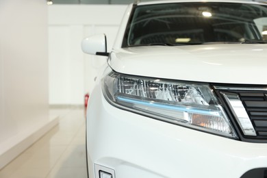 Photo of New modern white car in salon, closeup. Space for text