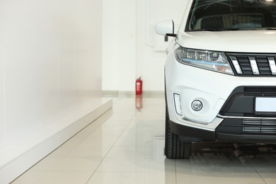 New modern white car in salon, space for text