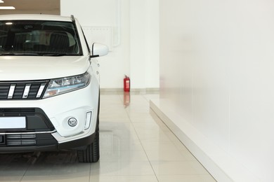 New modern white car in salon, space for text