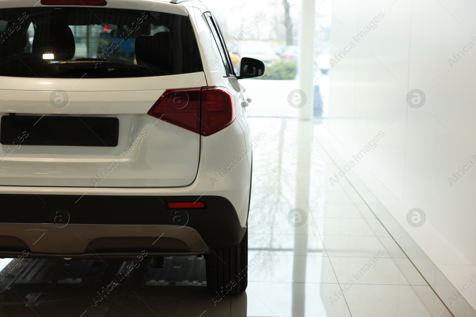 Photo of New modern white car in salon, space for text