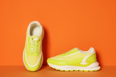 Photo of Stylish neon lime sneakers on color background