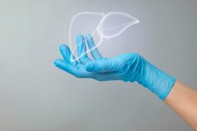 Image of Doctor holding illustration of liver on grey background, closeup