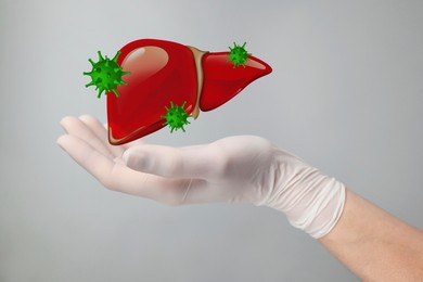 Doctor holding illustration of unhealthy liver on grey background, closeup. Hepatitis