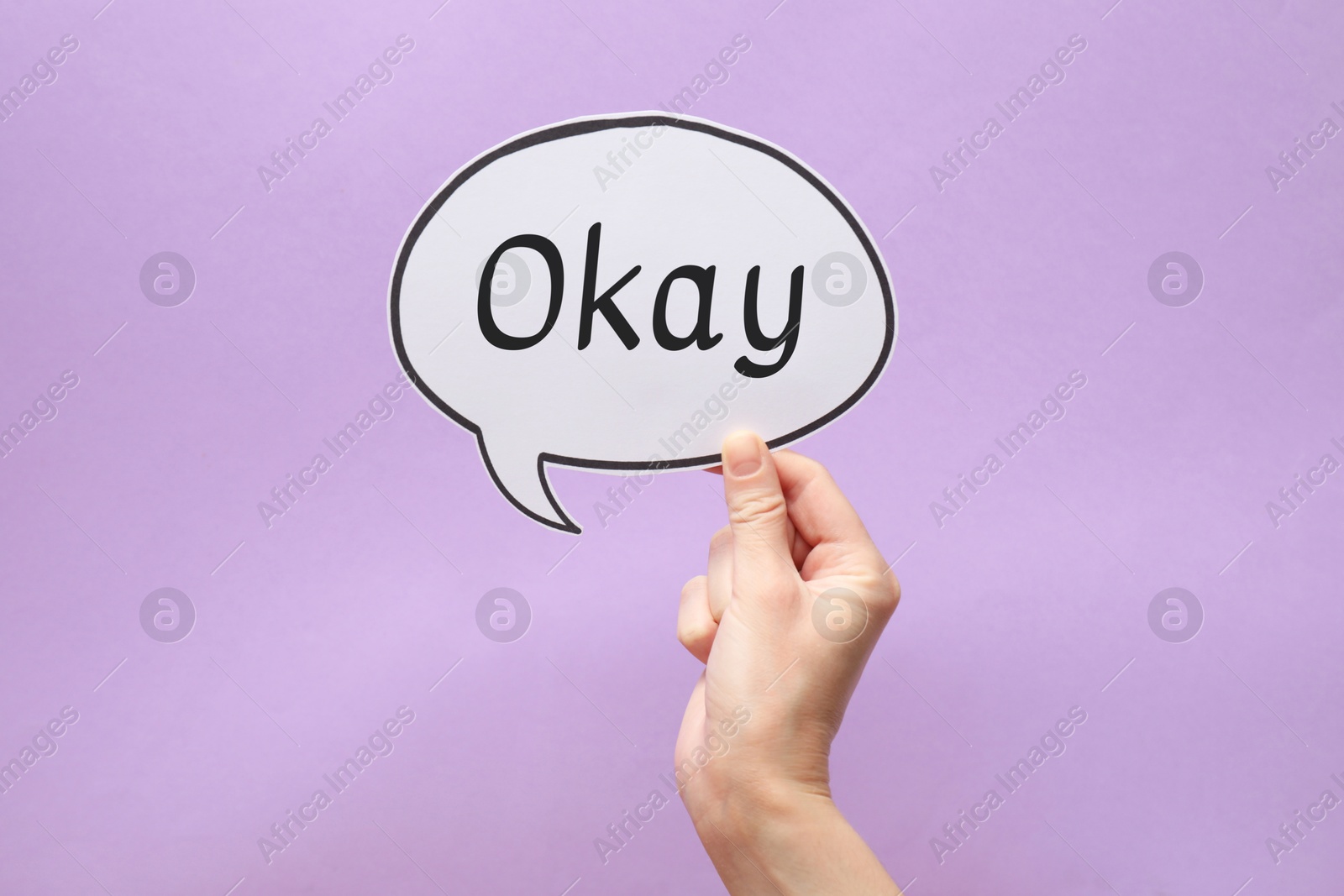 Image of Woman holding paper speech bubble with word Okay on lilac background, closeup