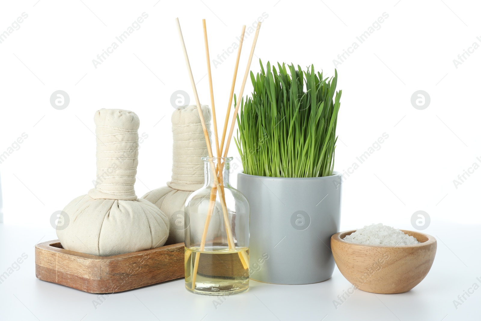 Photo of Spa composition with wheatgrass and herbal bags on white background