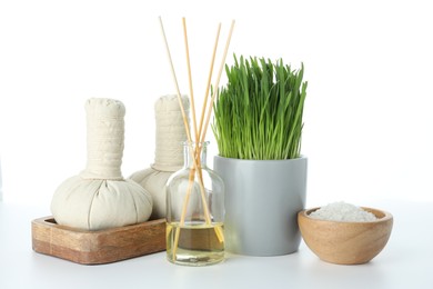 Spa composition with wheatgrass and herbal bags on white background