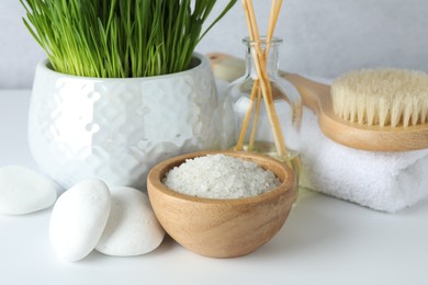 Photo of Spa composition with wheatgrass and sea salt on white table, closeup