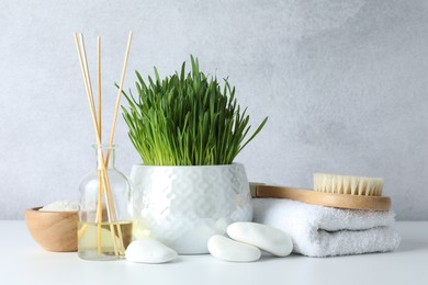 Photo of Spa composition with wheatgrass on white table