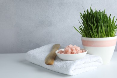 Photo of Spa composition with wheatgrass and sea salt on white table. Space for text