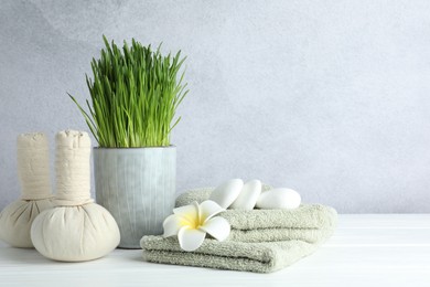 Photo of Spa composition with wheatgrass on white table against light grey background. Space for text