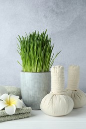 Photo of Spa composition with wheatgrass on white table against light grey background