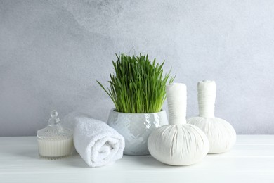 Photo of Spa composition with wheatgrass on white table against light grey background