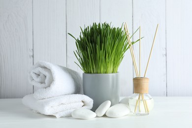 Photo of Spa composition with wheatgrass on white table