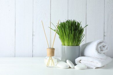 Photo of Spa composition with wheatgrass on white table. Space for text