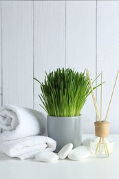 Photo of Spa composition with wheatgrass on white table