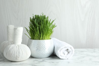 Spa composition with wheatgrass on white marble table. Space for text