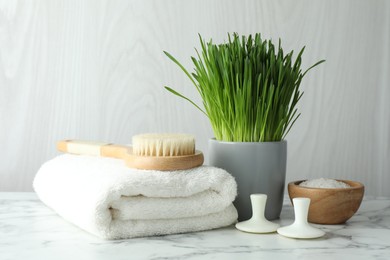 Photo of Spa composition with wheatgrass on white marble table