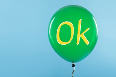 Green balloon with abbreviation OK on light blue background, space for text