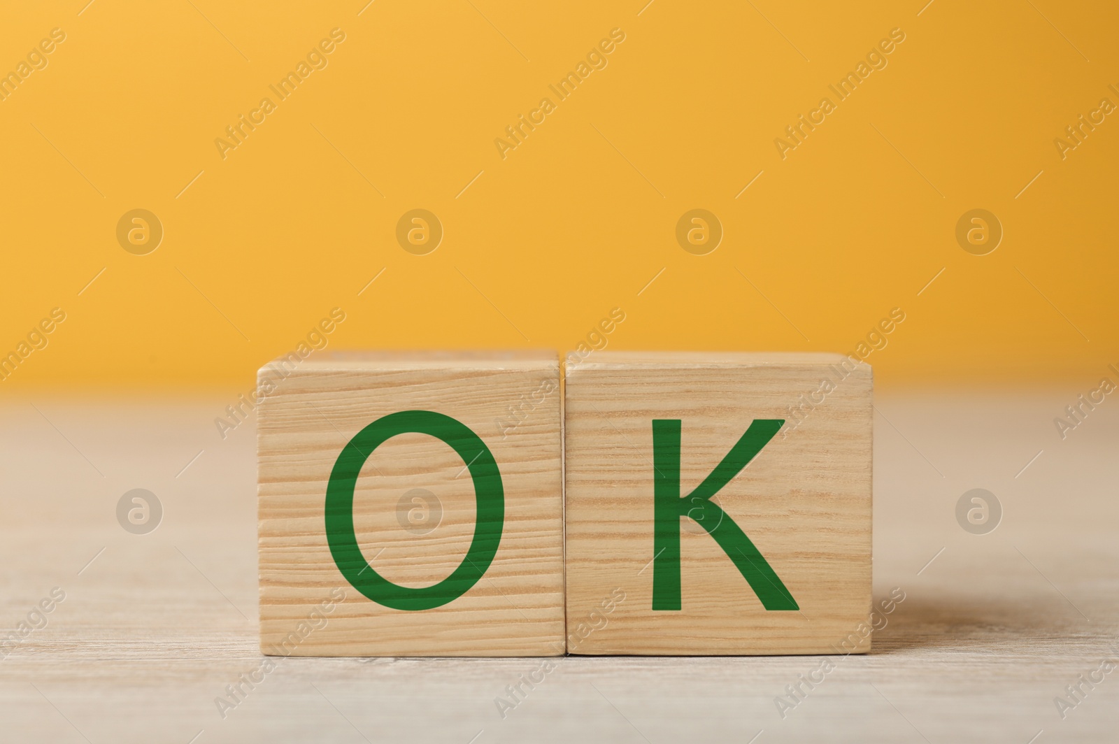 Image of Wooden cubes with abbreviation OK on table, closeup