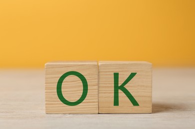 Image of Wooden cubes with abbreviation OK on table, closeup