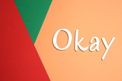 Image of Word Okay on color background, top view