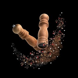 Image of Salt and pepper mills in air on black background