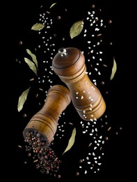 Image of Salt and pepper mills in air on black background