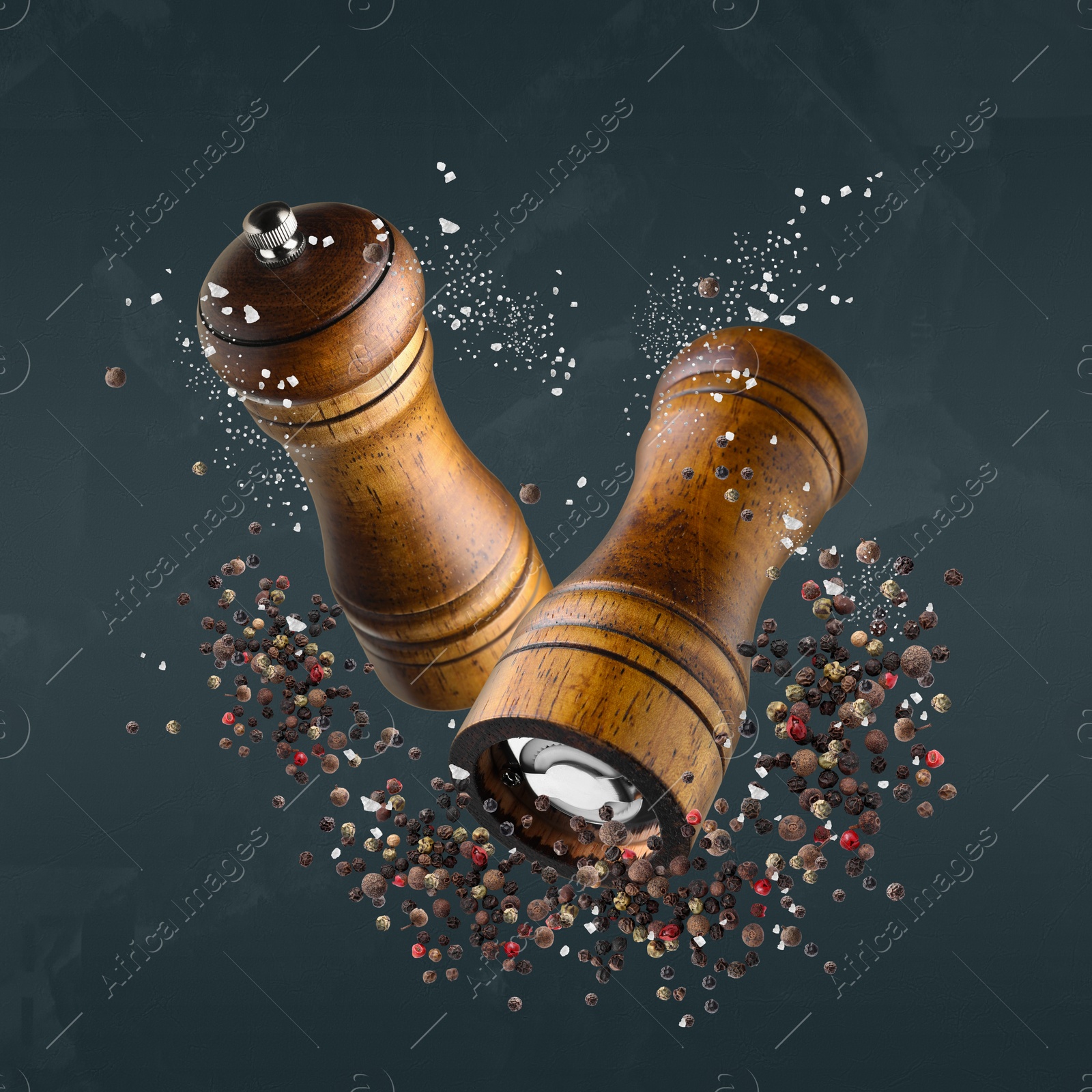 Image of Salt and pepper mills in air on dark blue background