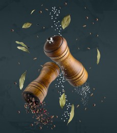 Image of Salt and pepper mills in air on dark blue background